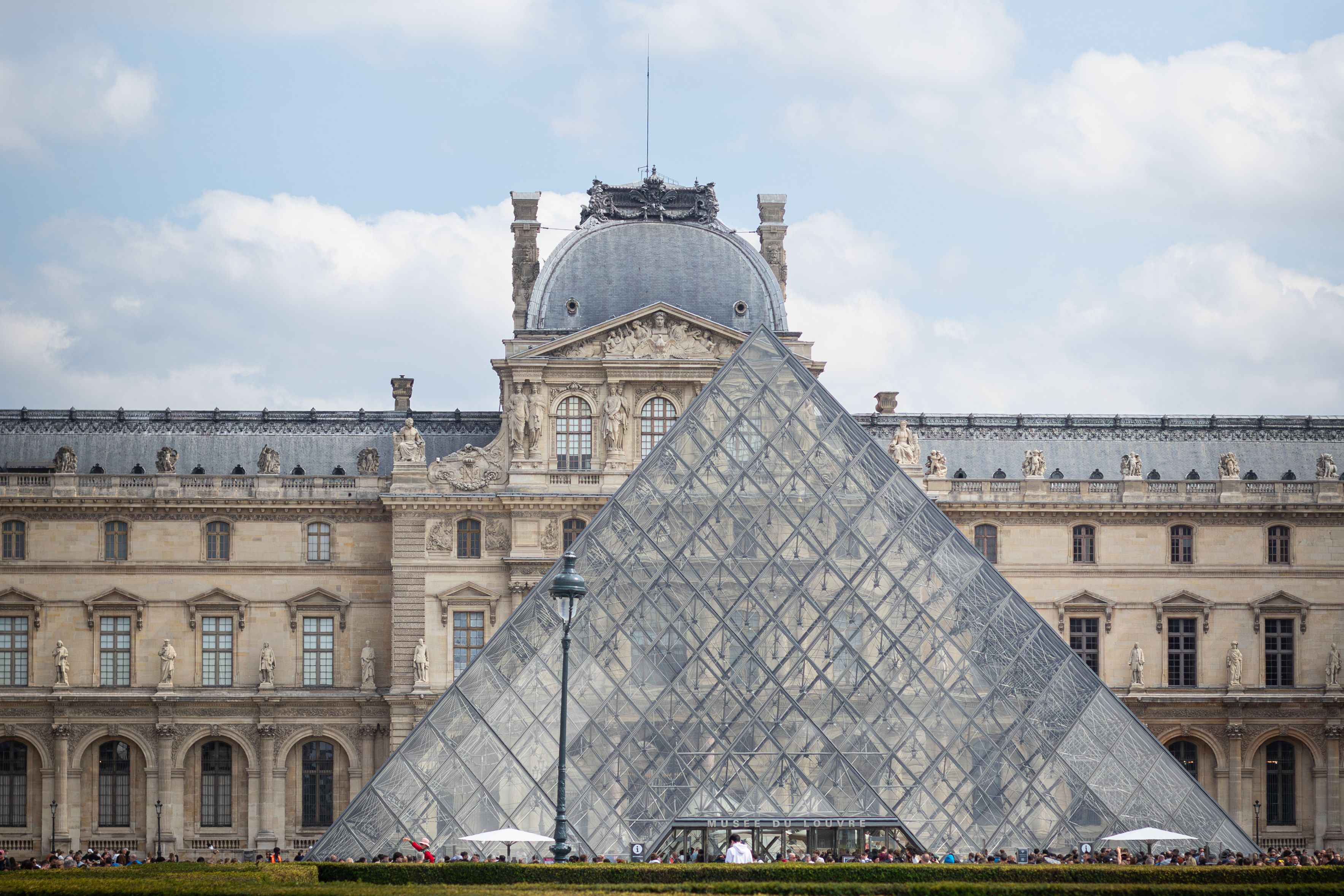 Stunning view of the Louvre Museum and its iconic glass pyramid in Paris, France.