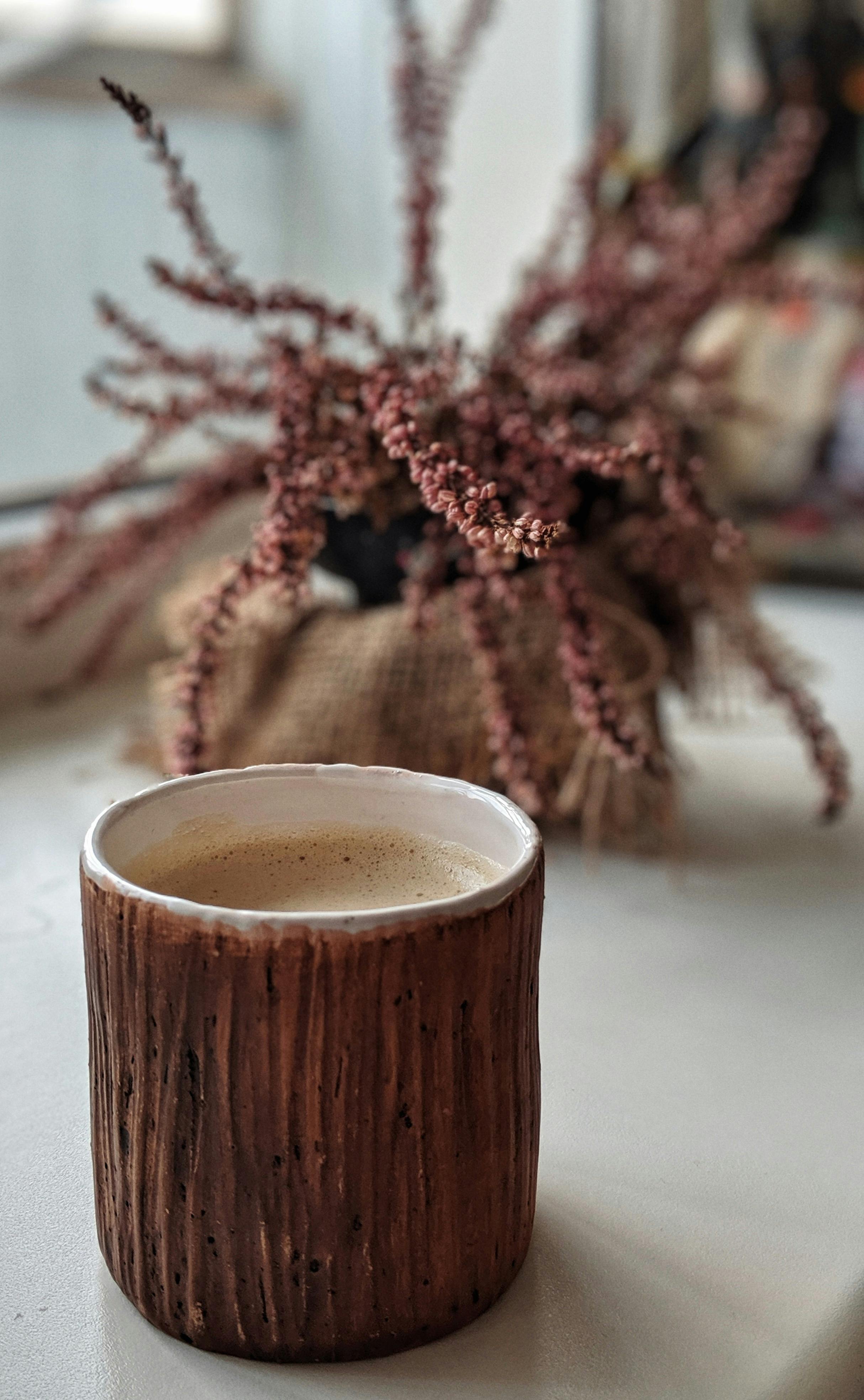 brown ceramic mug with brown liquid inside