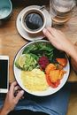 Person Touching Cup of Coffee and Plate with Food