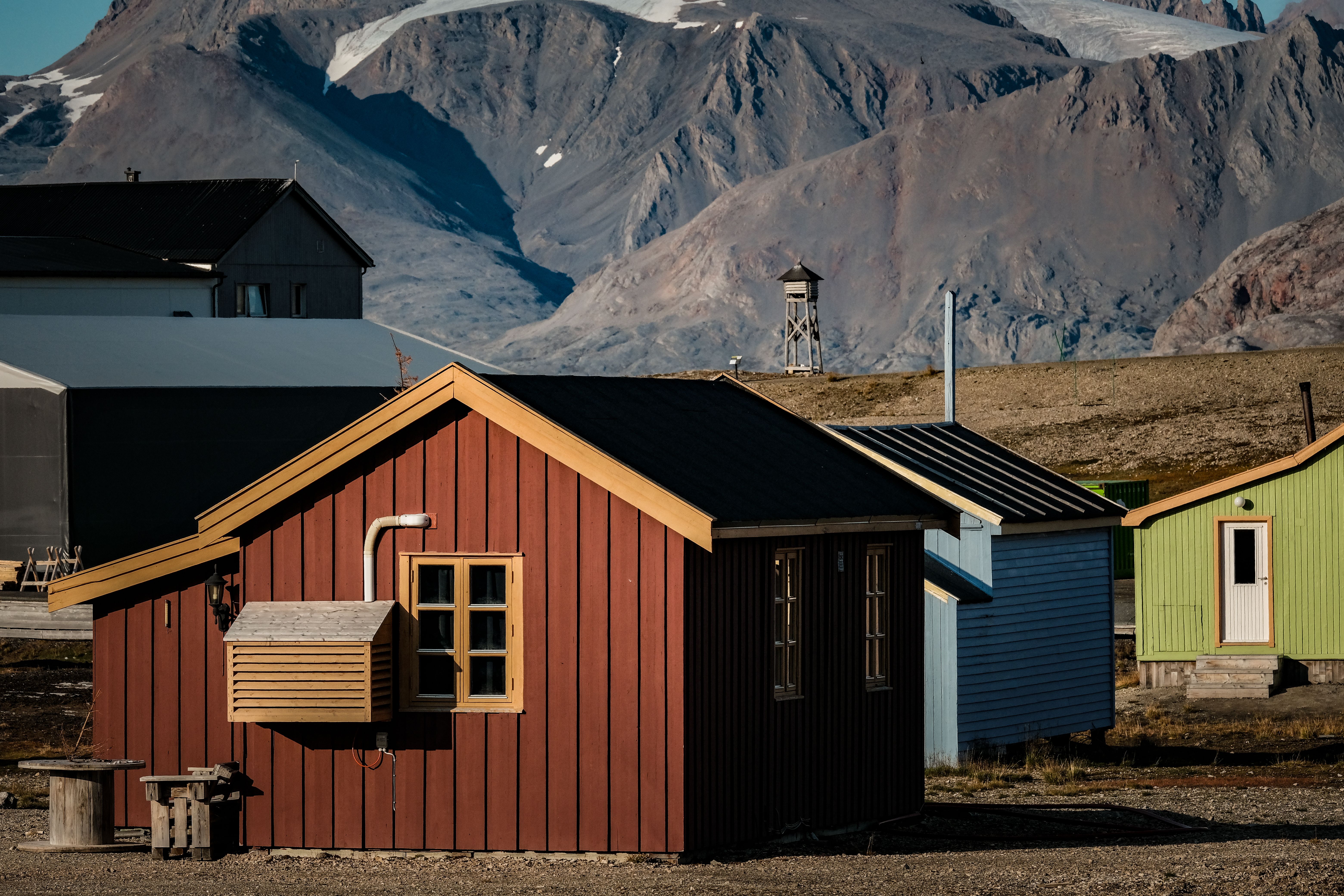 Colorful cabins with mountains in the backdrop create a serene Nordic landscape.