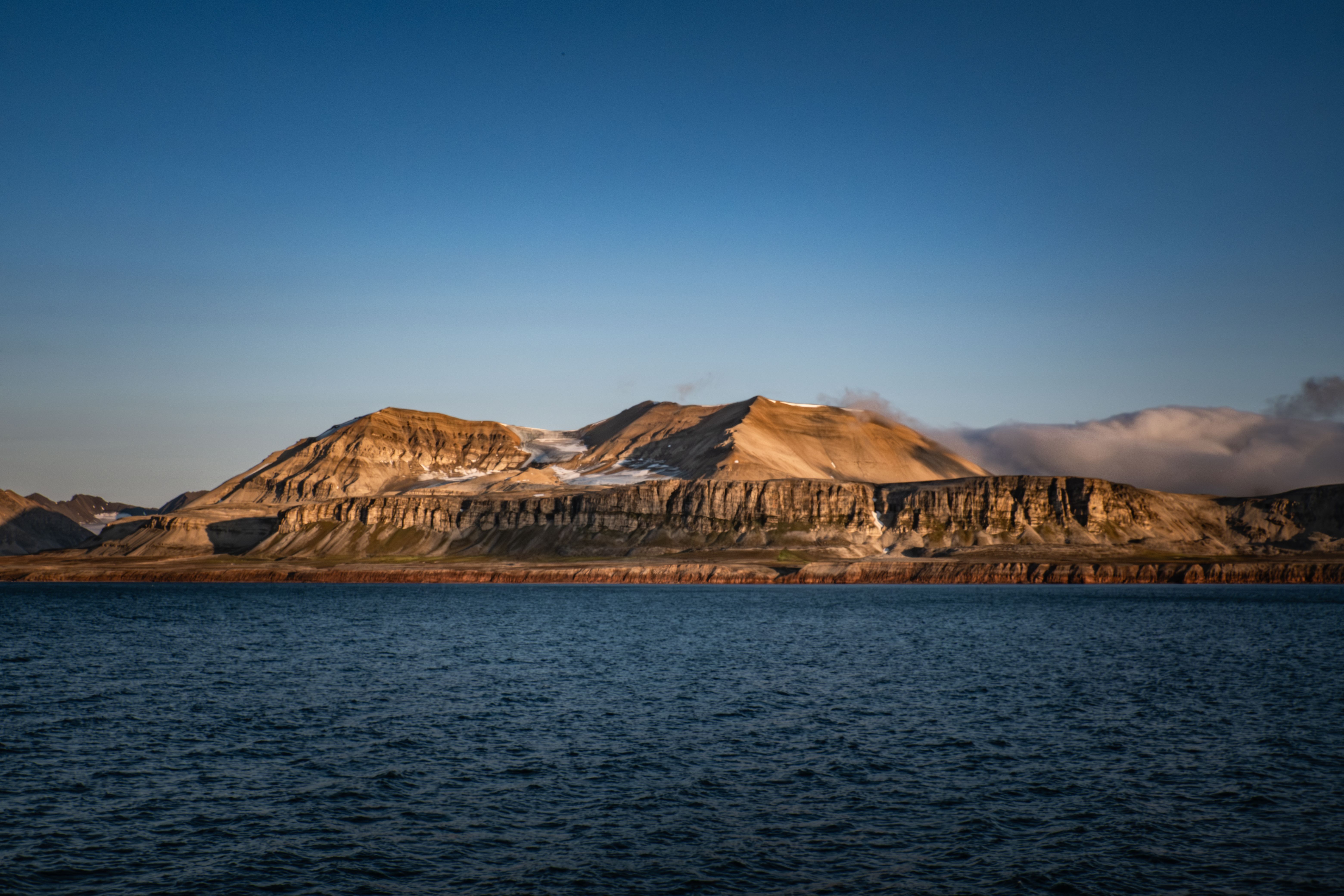 Breathtaking view of mountains and sea under a vibrant sunset sky.