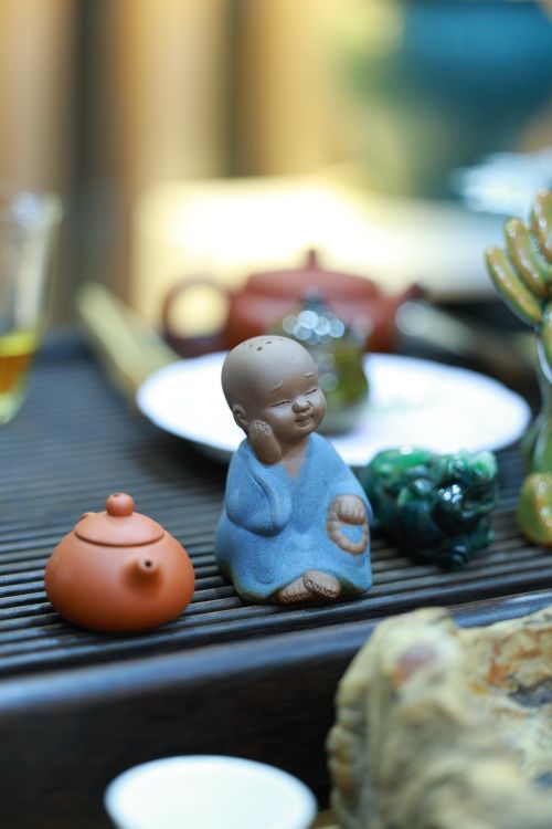 Free Charming ceramic figurine with a teapot on a wooden surface, capturing an artistic still life. Stock Photo