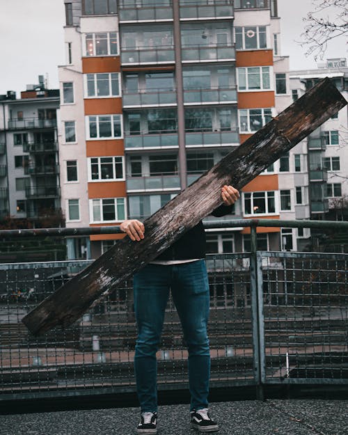 Personne En Jeans Denim Bleu Debout Tenant Une Bûche En Bois