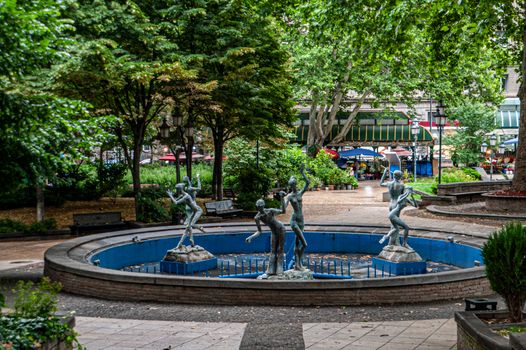 An artistic fountain with graceful sculptures in a lush city park, perfect for cultural exploration.