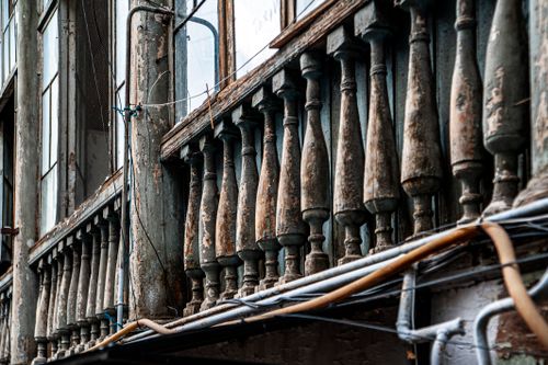 Free Close-up of a weathered wooden balustrade on an old building facade showcasing vintage architectural design. Stock Photo
