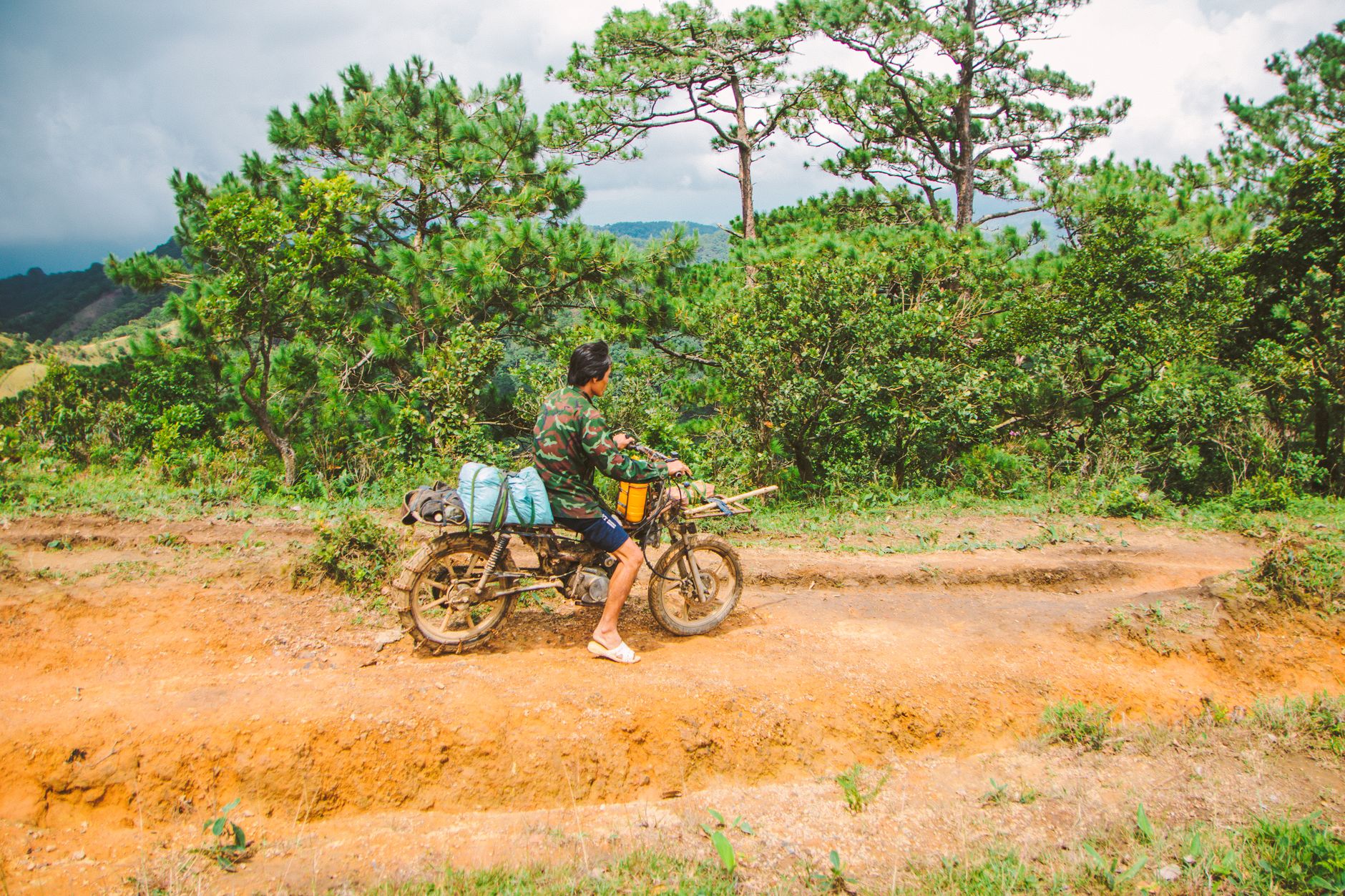 Un uomo in sella a una moto attraverso la pittoresca campagna di Lâm Đồng, in Vietnam.