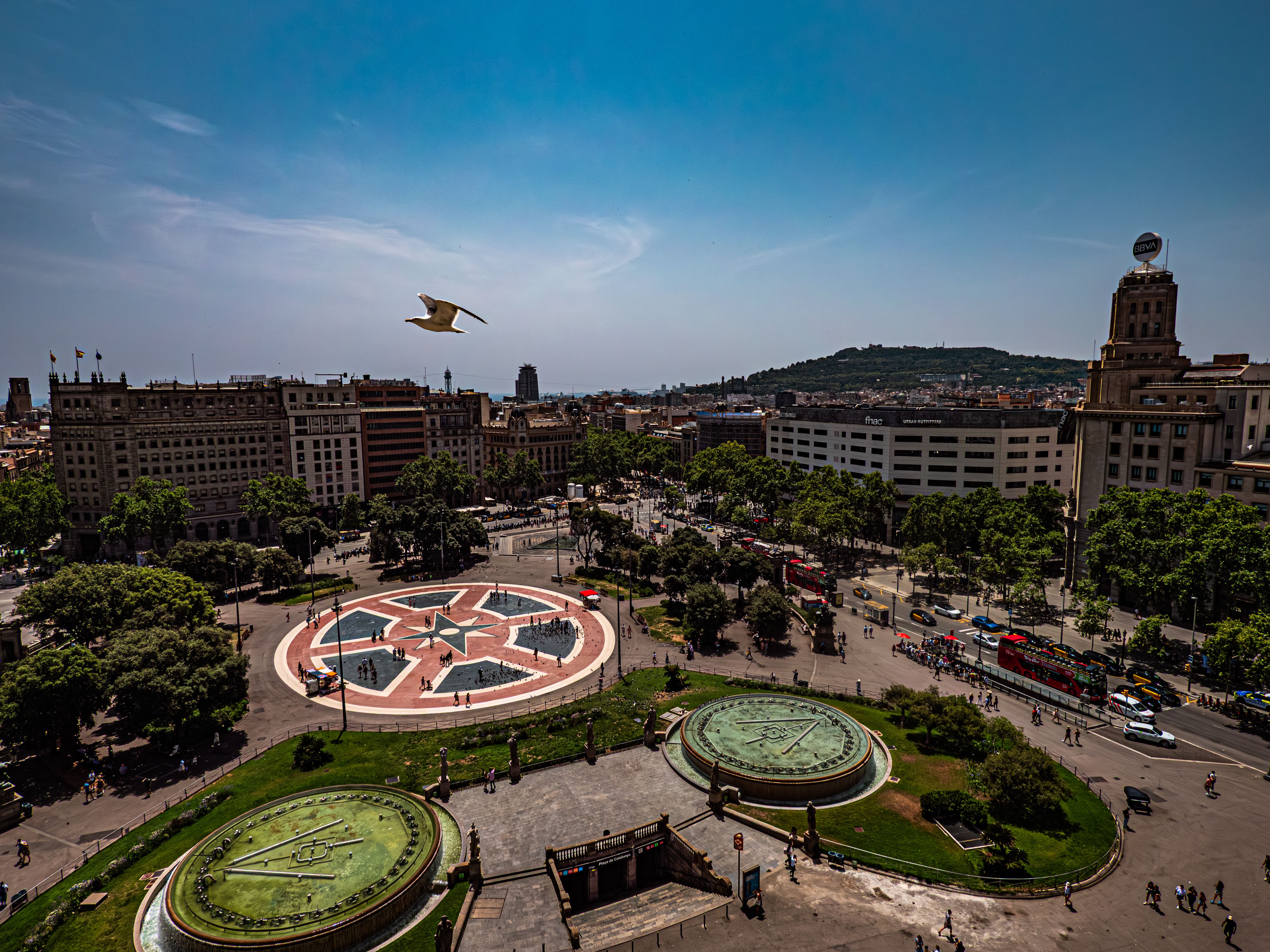 Explore the bustling Plaça de Catalunya in Barcelona with this vibrant aerial view, capturing urban life and architecture. Explore the bustling Plaça de Catalunya in Barcelona with this vibrant aerial view, capturing urban life and architecture.