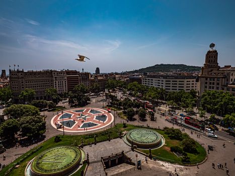 Explore the bustling Plaça de Catalunya in Barcelona with this vibrant aerial view, capturing urban life and architecture.