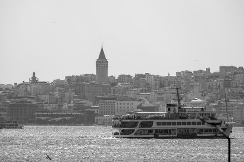 Free A black and white image showcasing the iconic Galata Tower and a ferry crossing the Bosphorus in Istanbul. Stock Photo