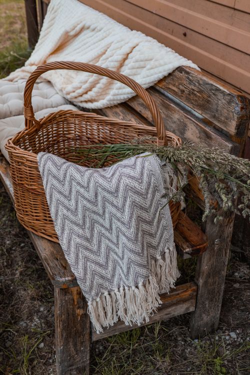 Free A rustic bench with a wicker basket, blanket, and decorative dried plants creates a cozy autumn vibe. Stock Photo