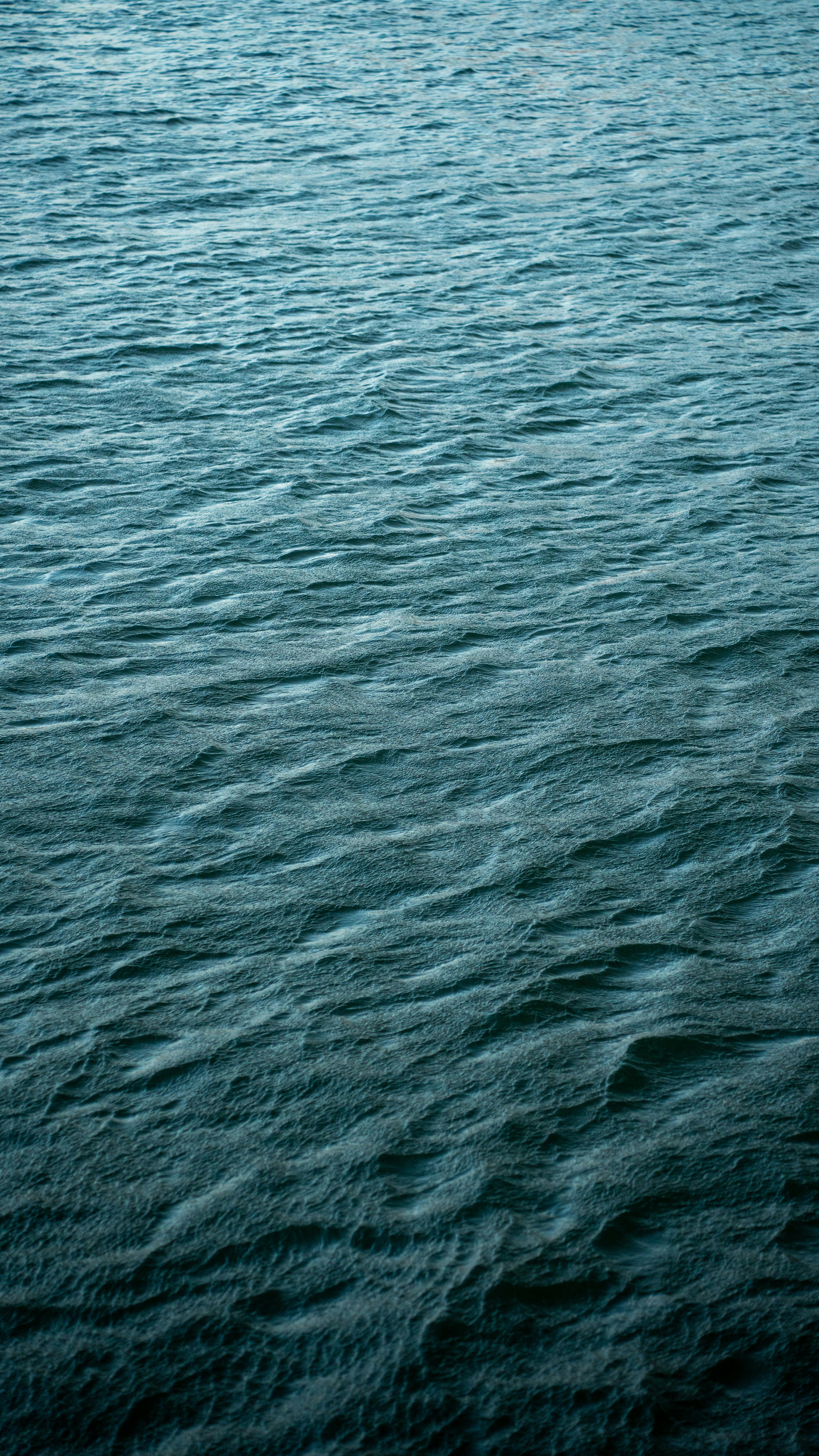 grátis Uma vista tranquila das ondas azuis do oceano, evocando paz e calma. Foto profissional