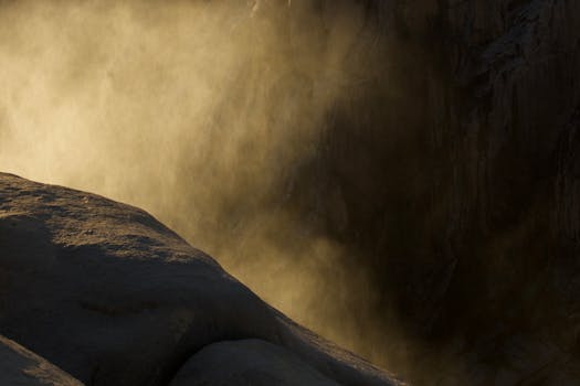 Sunlight illuminating mist at Augrabies Falls, creating a dramatic play of light and shadow.