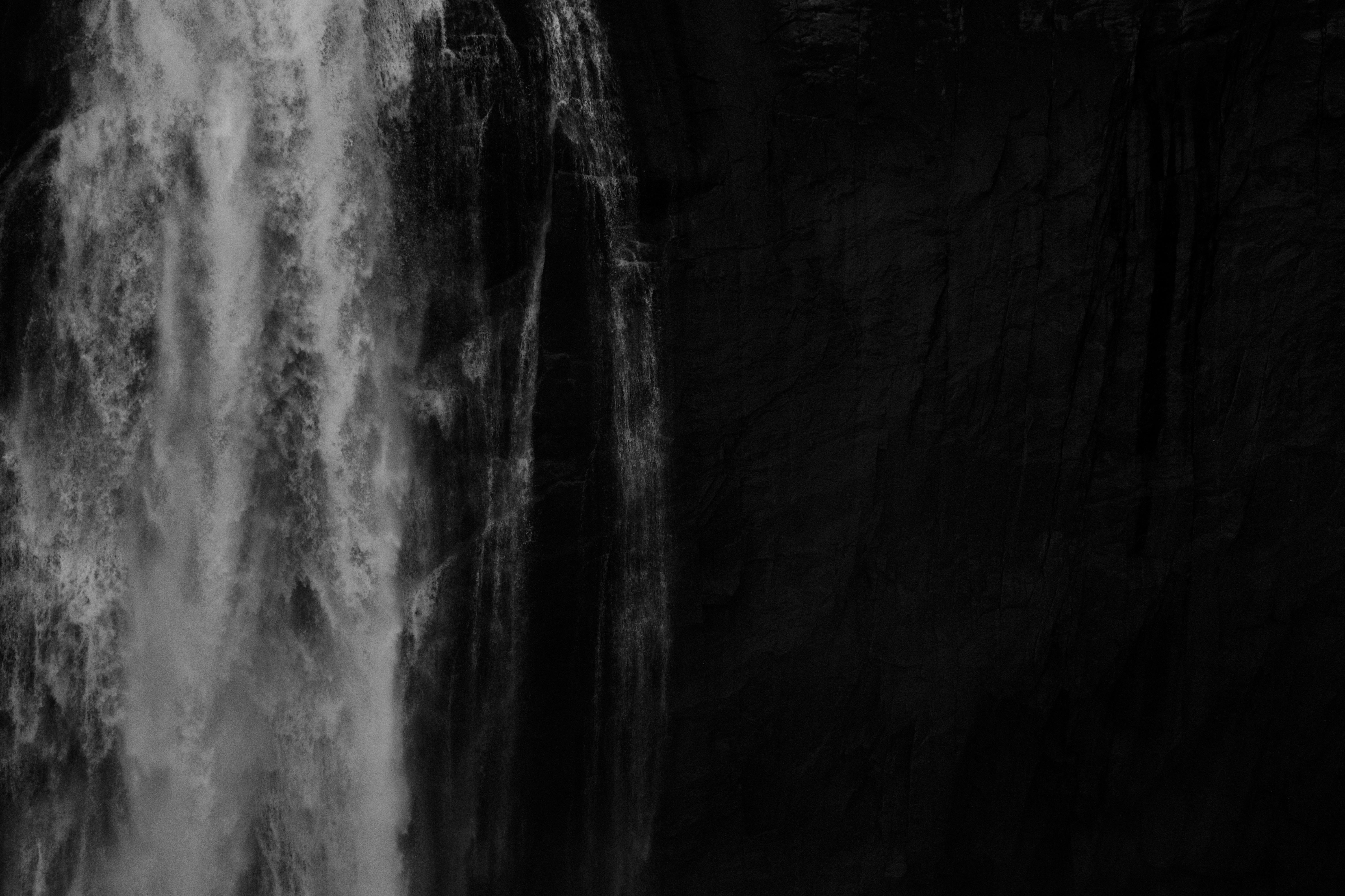 Stunning black and white photograph of a waterfall cascading down a dark rock surface.