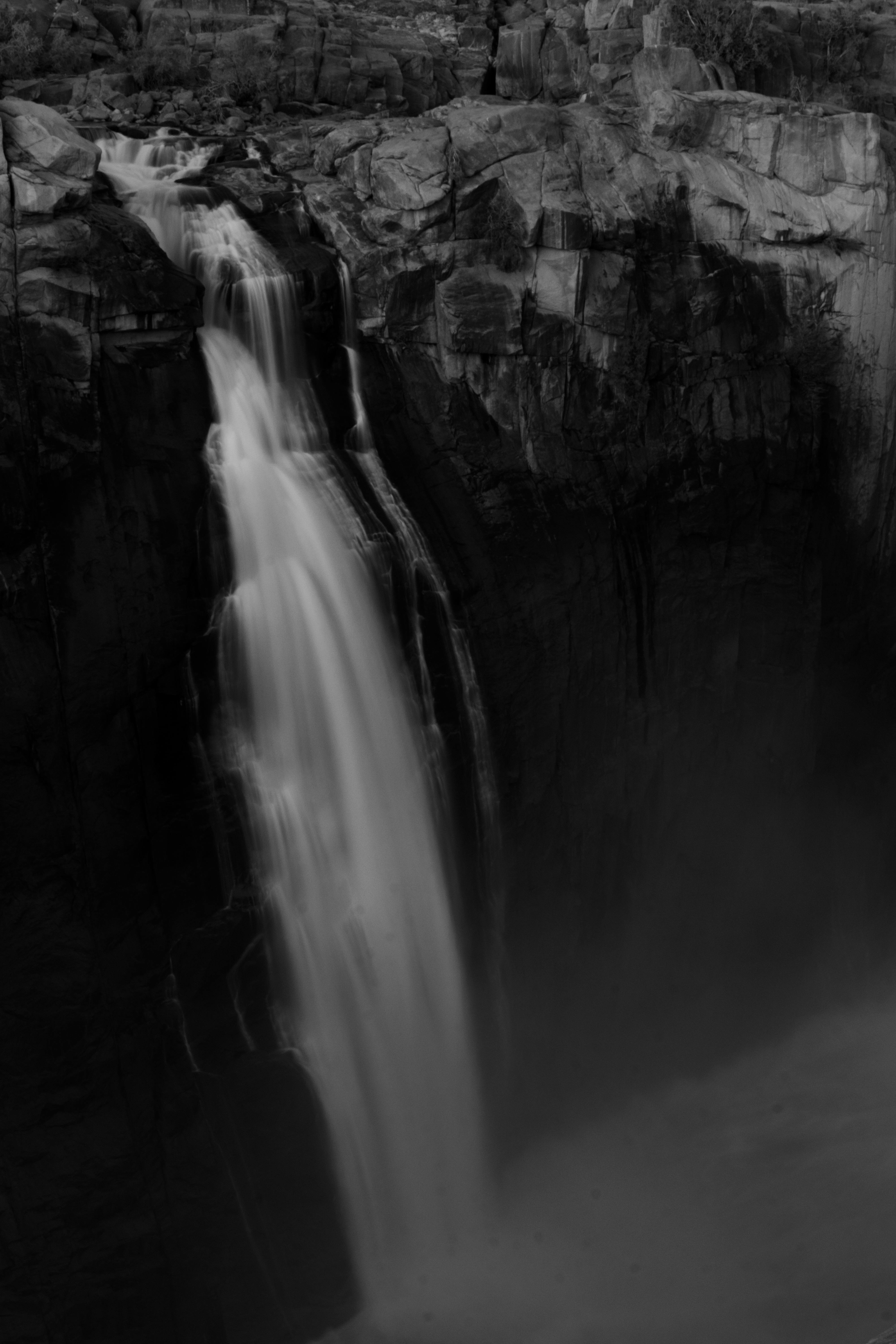A captivating monochromatic waterfall captured in long exposure, highlighting intricate water cascades.