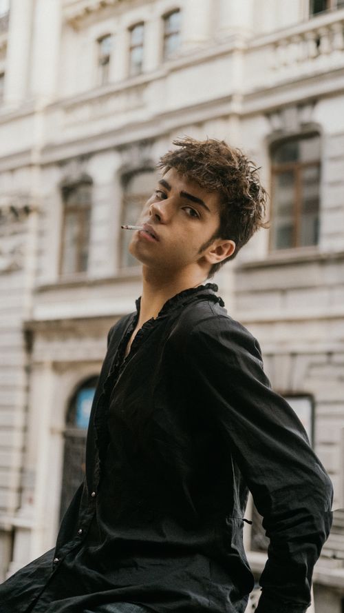 Free Young male posing against historic Istanbul architecture, wearing a black shirt. Captures urban and stylish vibes. Stock Photo