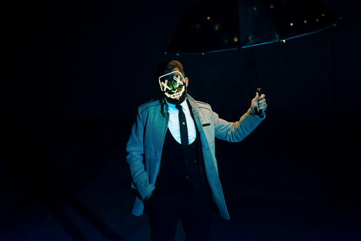 A man in a LED mask holds an umbrella, exuding a mysterious and eerie vibe.