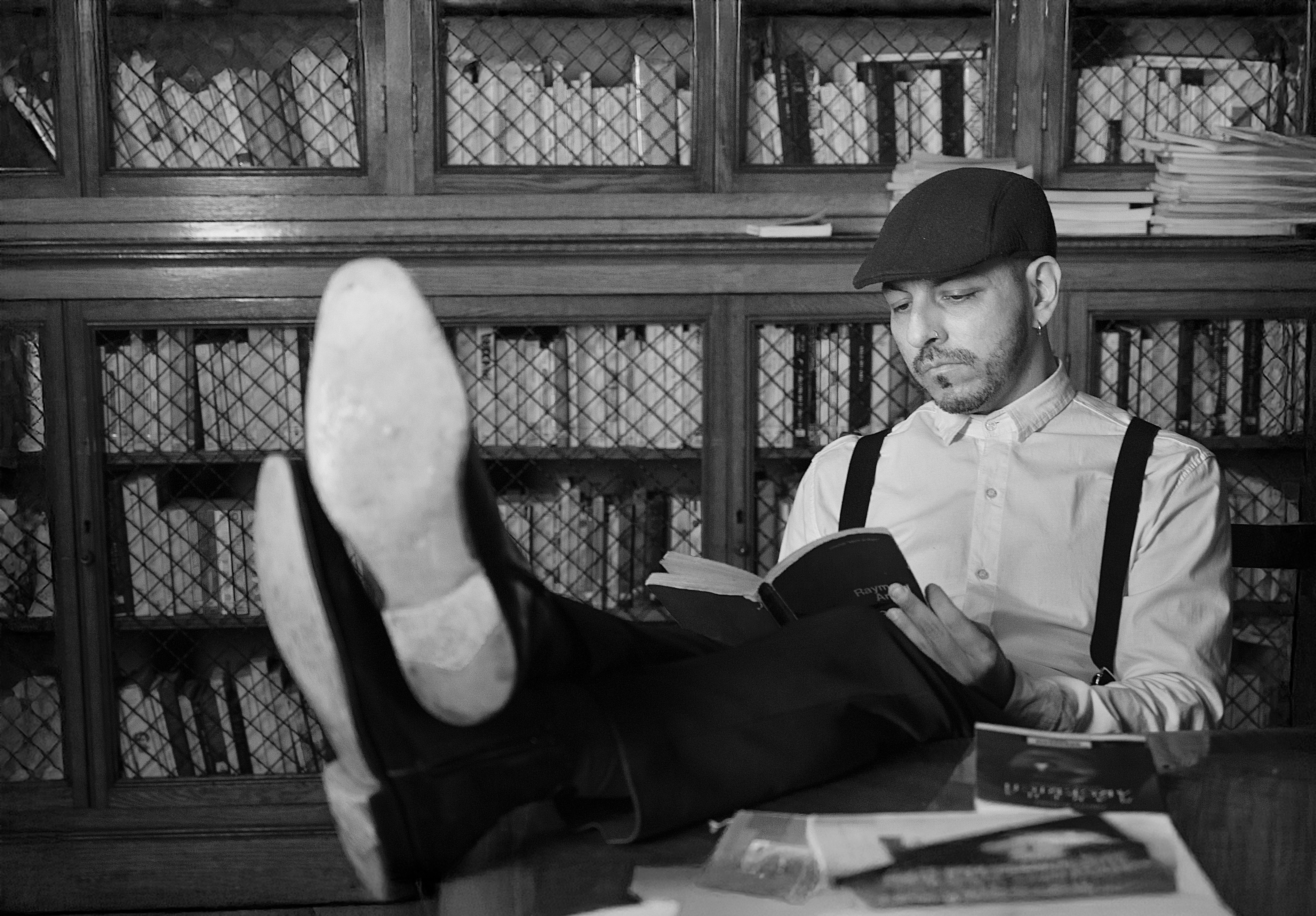 Gratis Foto in bianco e nero di un uomo che legge in una biblioteca d'epoca. Foto a disposizione