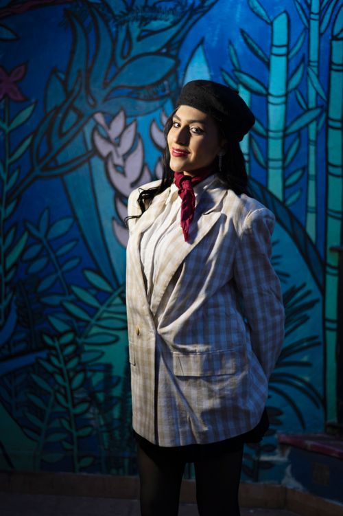 Free Stylish woman in a suit and hat against a colorful mural backdrop in Buenos Aires. Stock Photo