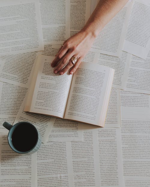 Fotografi Layak Dari Buku Terbuka Di Samping Mug Kopi