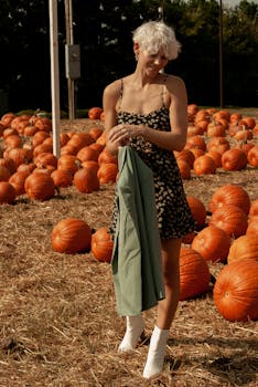 成年妇女在秋天的南瓜地里享受阳光明媚的一天