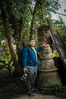 A person exploring an outdoor lush setting with camera equipment, showcasing adventure and travel.