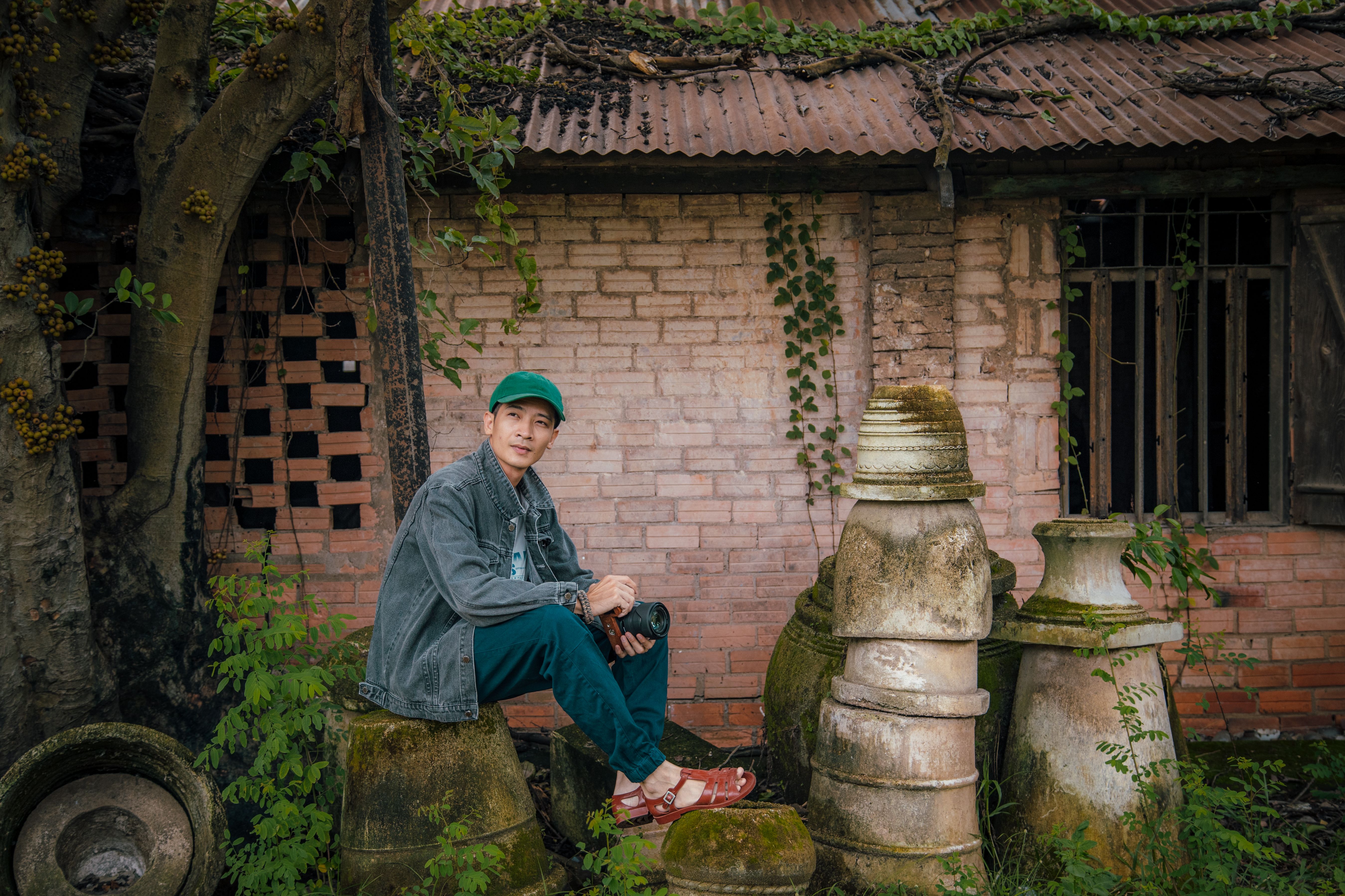 Man Sitting Near Rustic Brick Building Outdoors · Free Stock Photo
