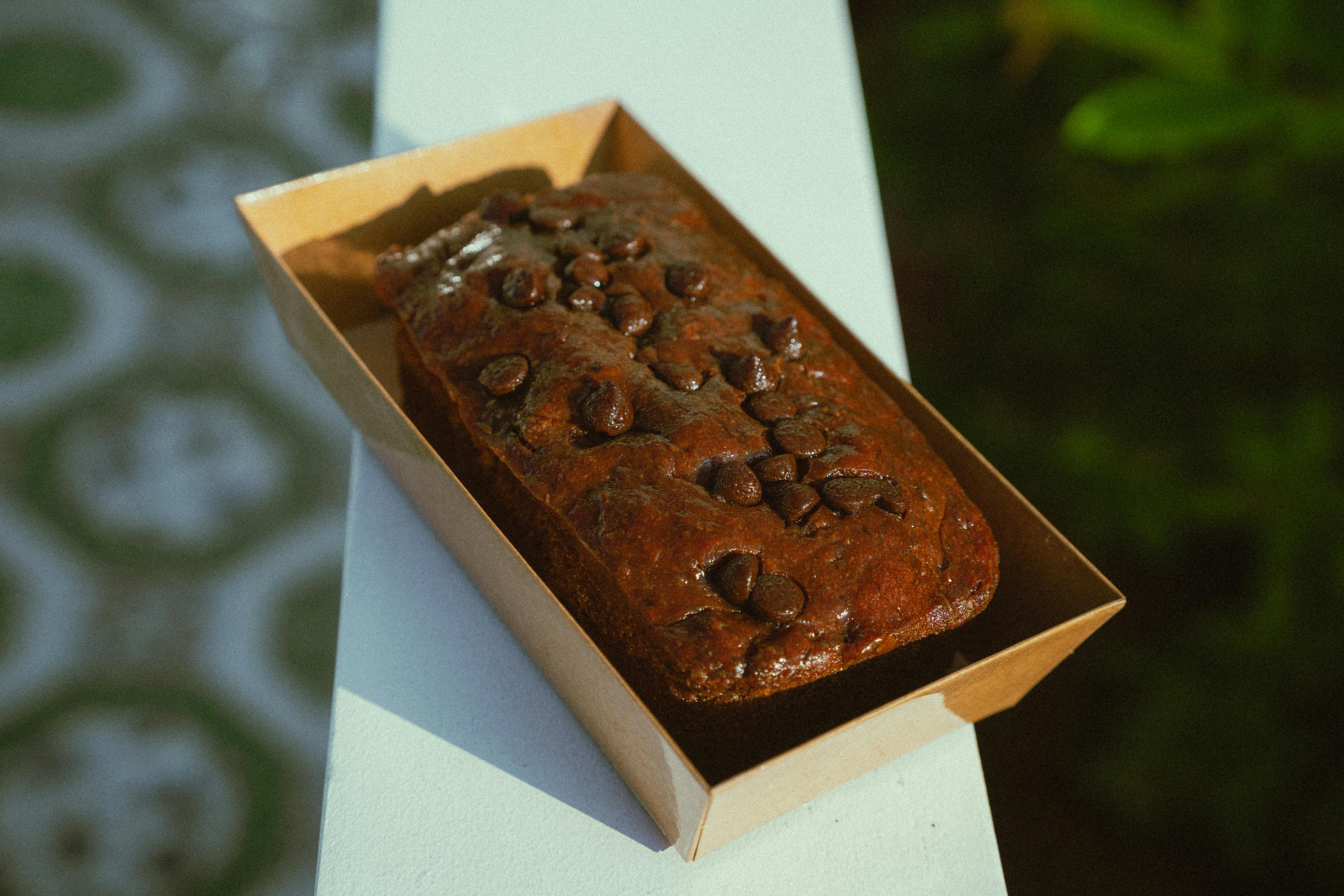 Mouth-watering chocolate chip cake in a box, outdoor setting. Perfect for food photography and dessert lovers.