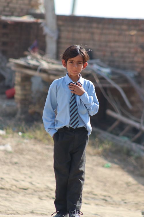 Free A young boy in a school uniform stands outdoors, exuding confidence. Stock Photo