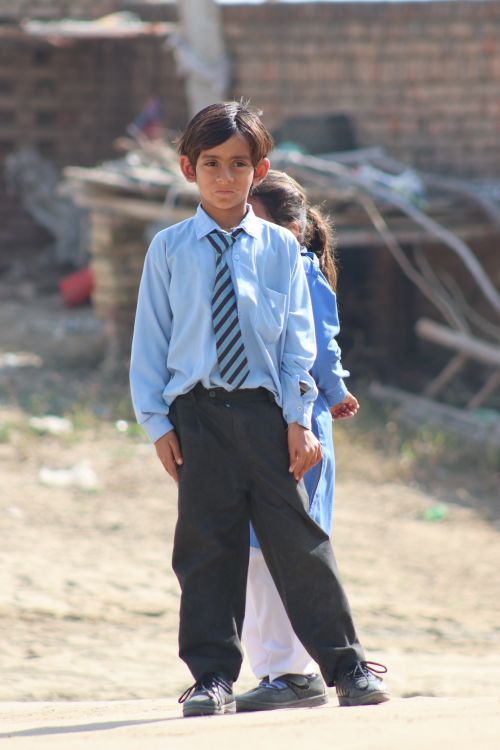 Free Children in school uniforms standing outdoors on a sunny day. Stock Photo