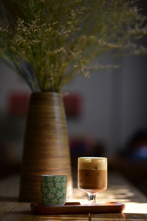 Free A stylish arrangement of coffee and tea with a vase of flowers in soft indoor lighting. Stock Photo