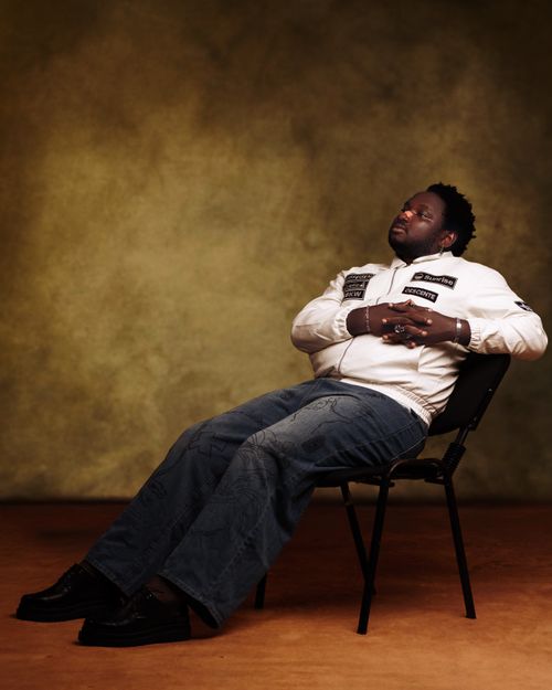 Free Portrait of a relaxed man in a studio, wearing a white jacket and jeans. Stock Photo