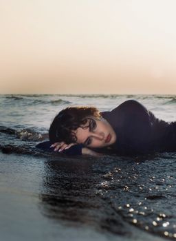Captivating portrait of a woman lying on the beach at sunset, exuding tranquility and connection with nature.