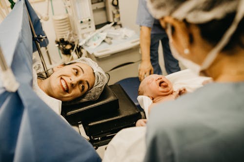 Mother Smiling Looking at Newborn Child