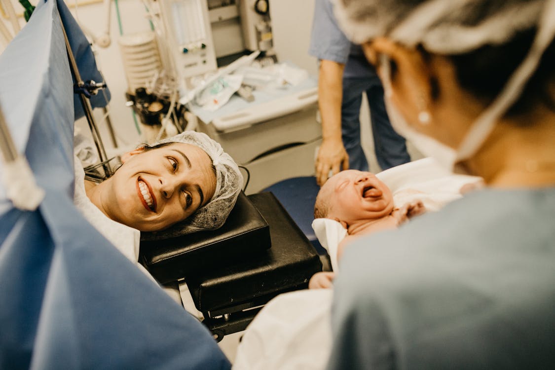 Free Mother Smiling Looking at Newborn Child Stock Photo