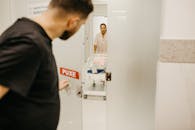 一名男子在护士看护的病房里打开一扇门，看到了他的新生儿