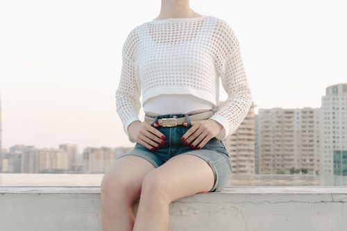 Free Stylish woman in urban setting, wearing summer fashion with a cityscape backdrop. Stock Photo