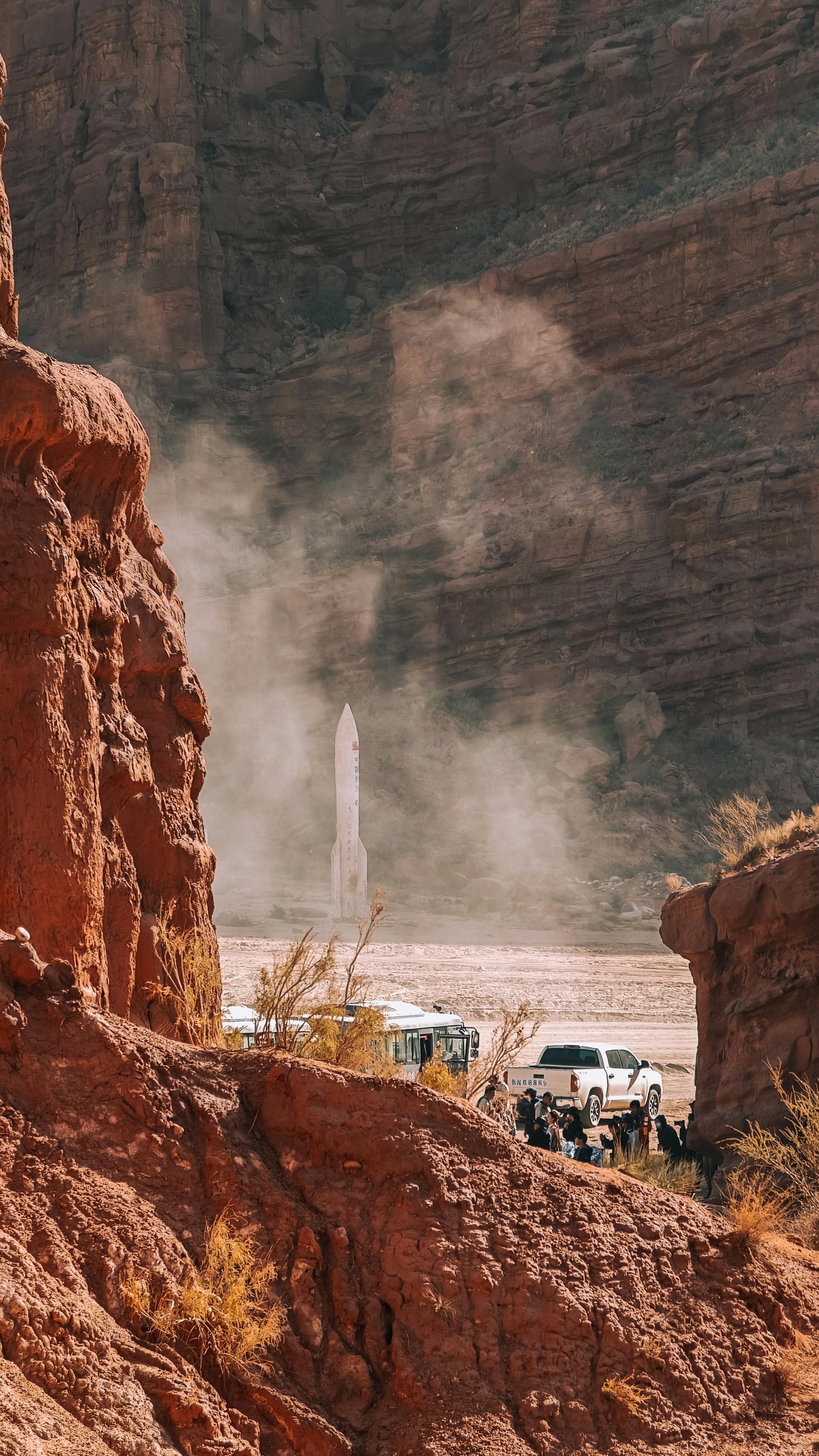 A dramatic view of a rocket launch amidst the red rock formations in Zhangye, Gansu, China.