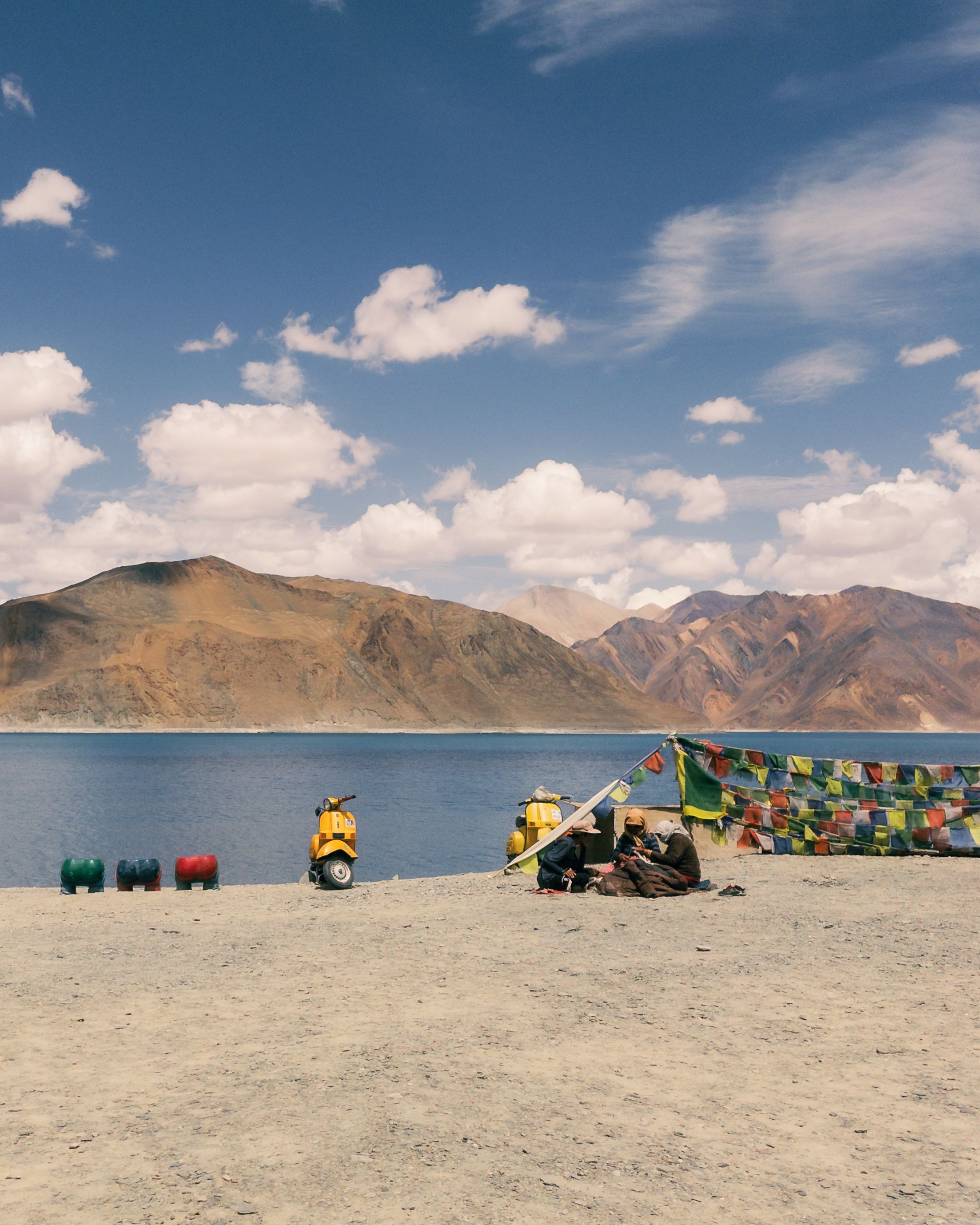 Gratis Fredelig udsigt over Pangong-søen i Ladakh, Indien, med farverige bedeflag og fjerne bjerge. Lagerfoto