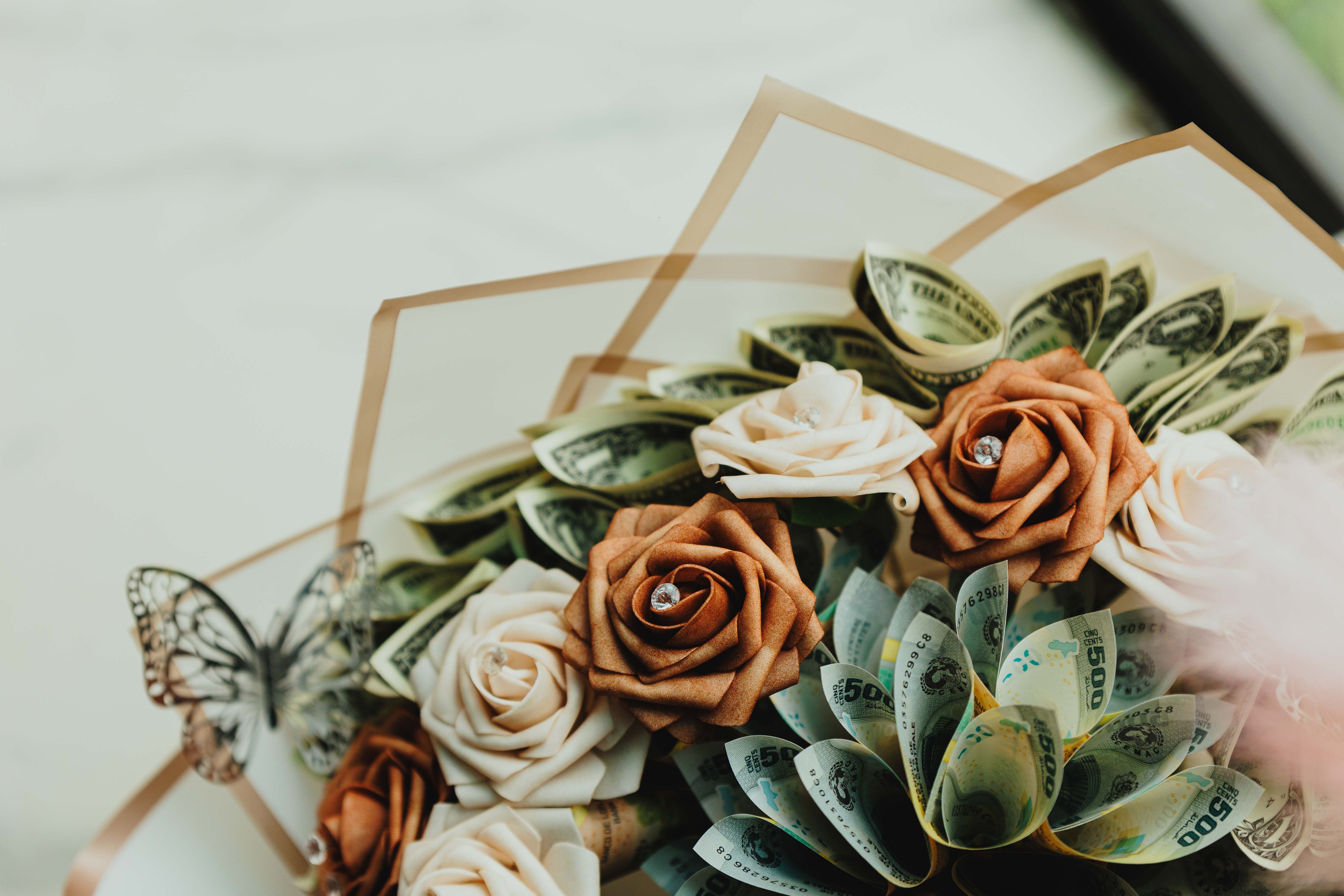 Aus Geldscheinen gefaltete Blume als Geschenk