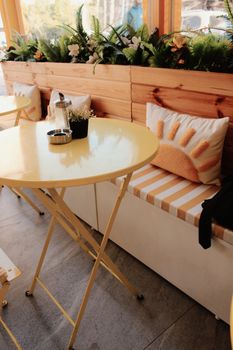 Charming outdoor cafe setting with sun-themed decor, perfect for relaxation or casual meetings.