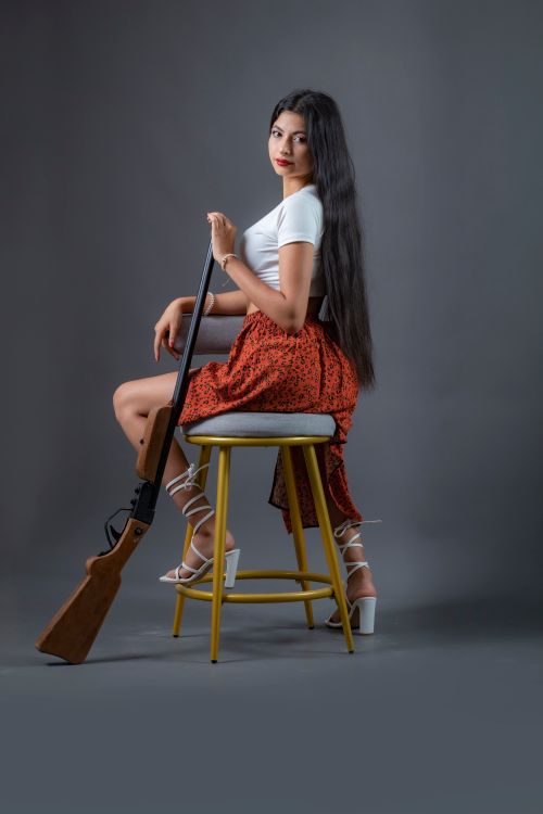 Stylish Woman Posing with Rifle in Studio · Free Stock Photo