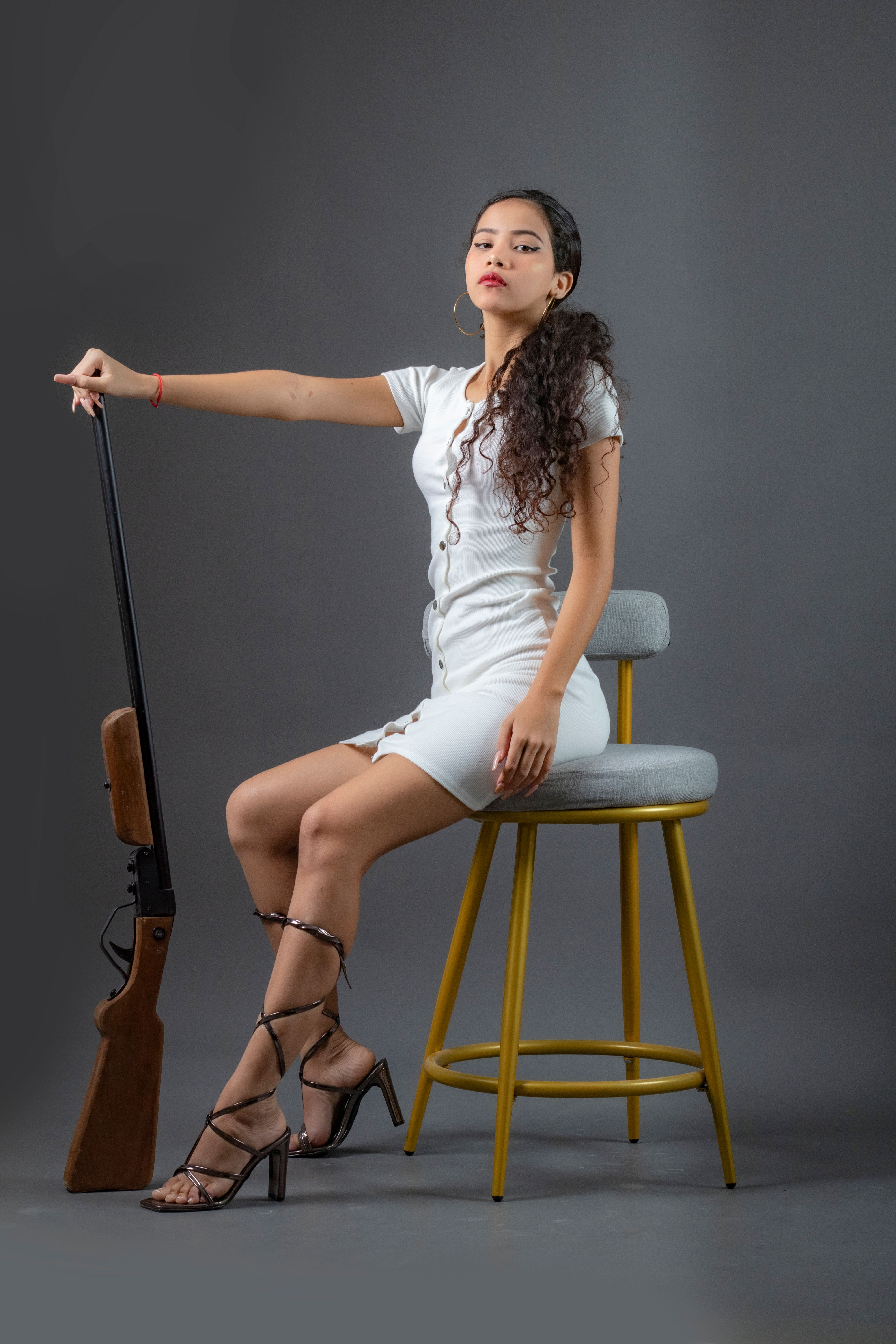 Confident Woman Posing with Air Rifle Indoors · Free Stock Photo
