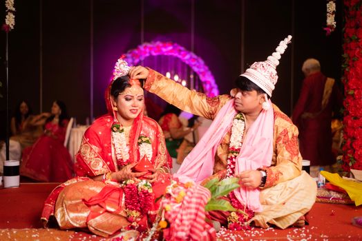 A vibrant scene from a traditional Indian wedding ceremony, highlighting the sindoor ritual.