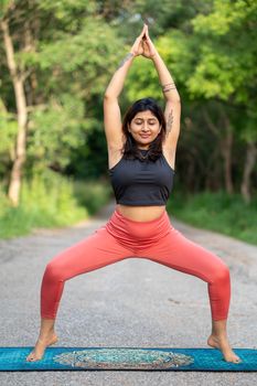 Yoga enthusiast practicing outdoors on a serene path, embodying tranquility and focus.