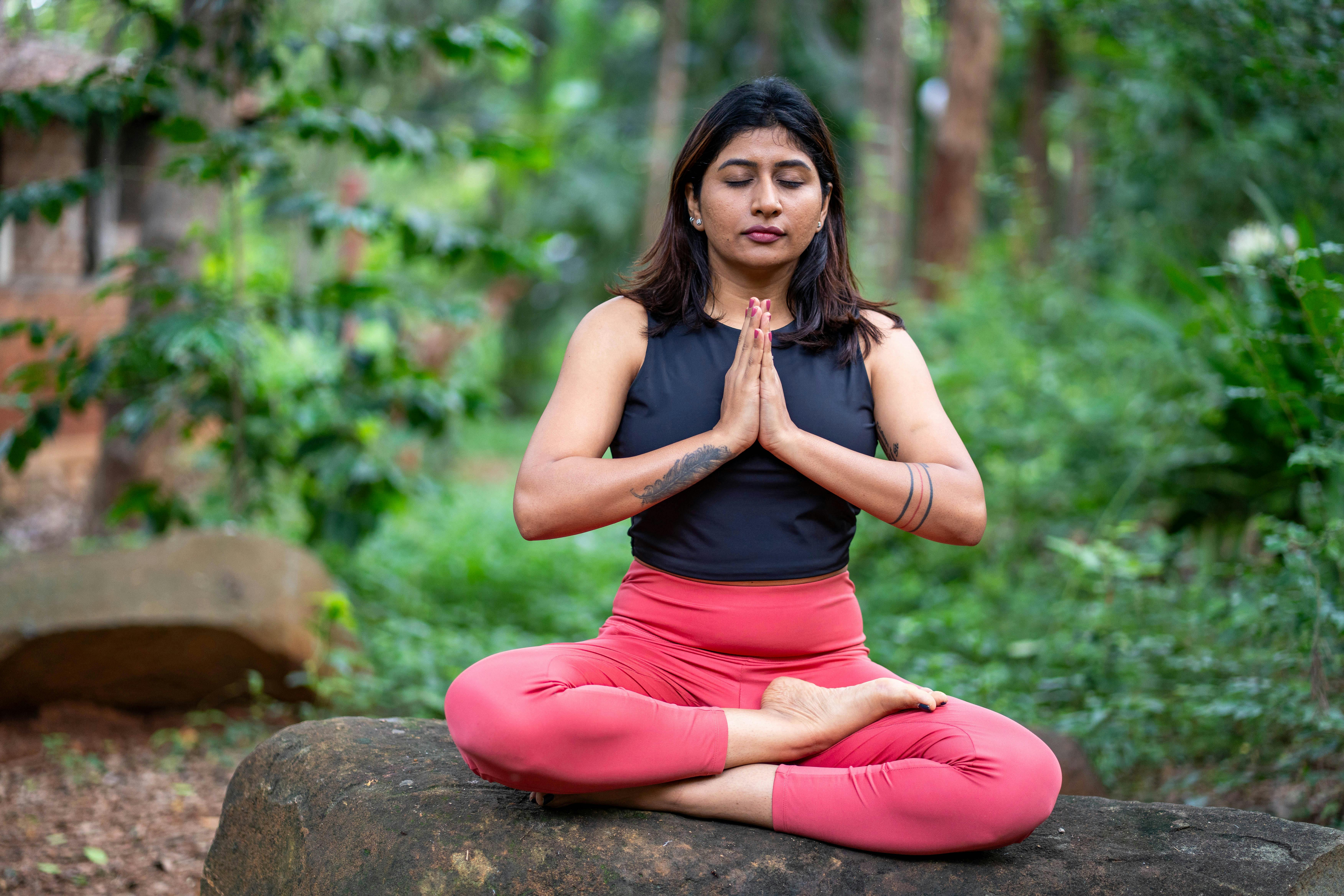 Woman practicing yoga in serene natural landscape