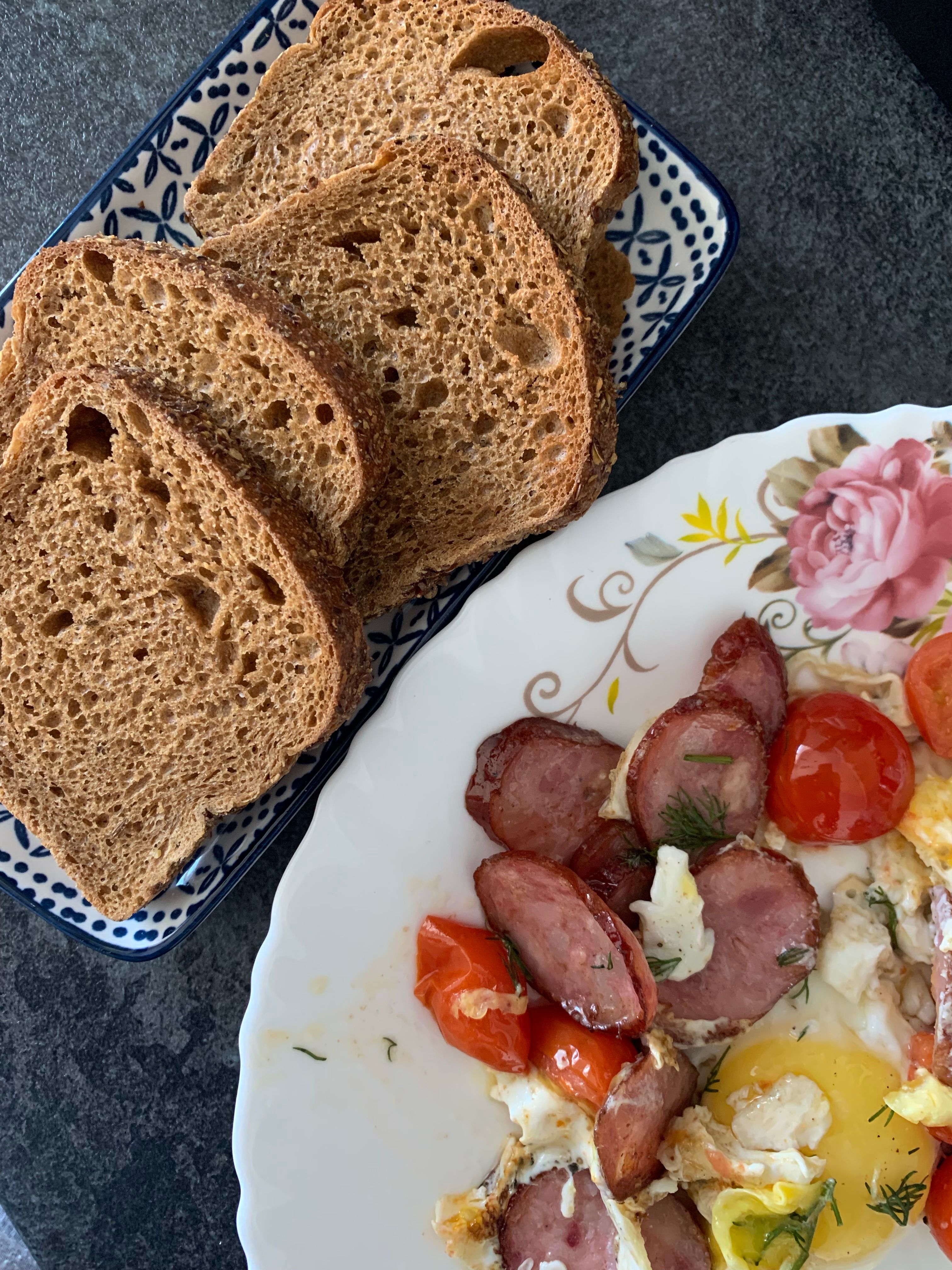 A hearty breakfast featuring sausage, egg, and fresh bread slices for a tasty start to the day.