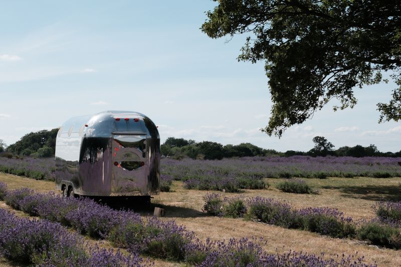 A polished travel trailer parked in an open field, photo by Mingyang LIU on Pexels