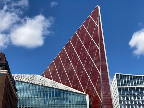 Striking modern architectural design of a London skyscraper against a clear blue sky.