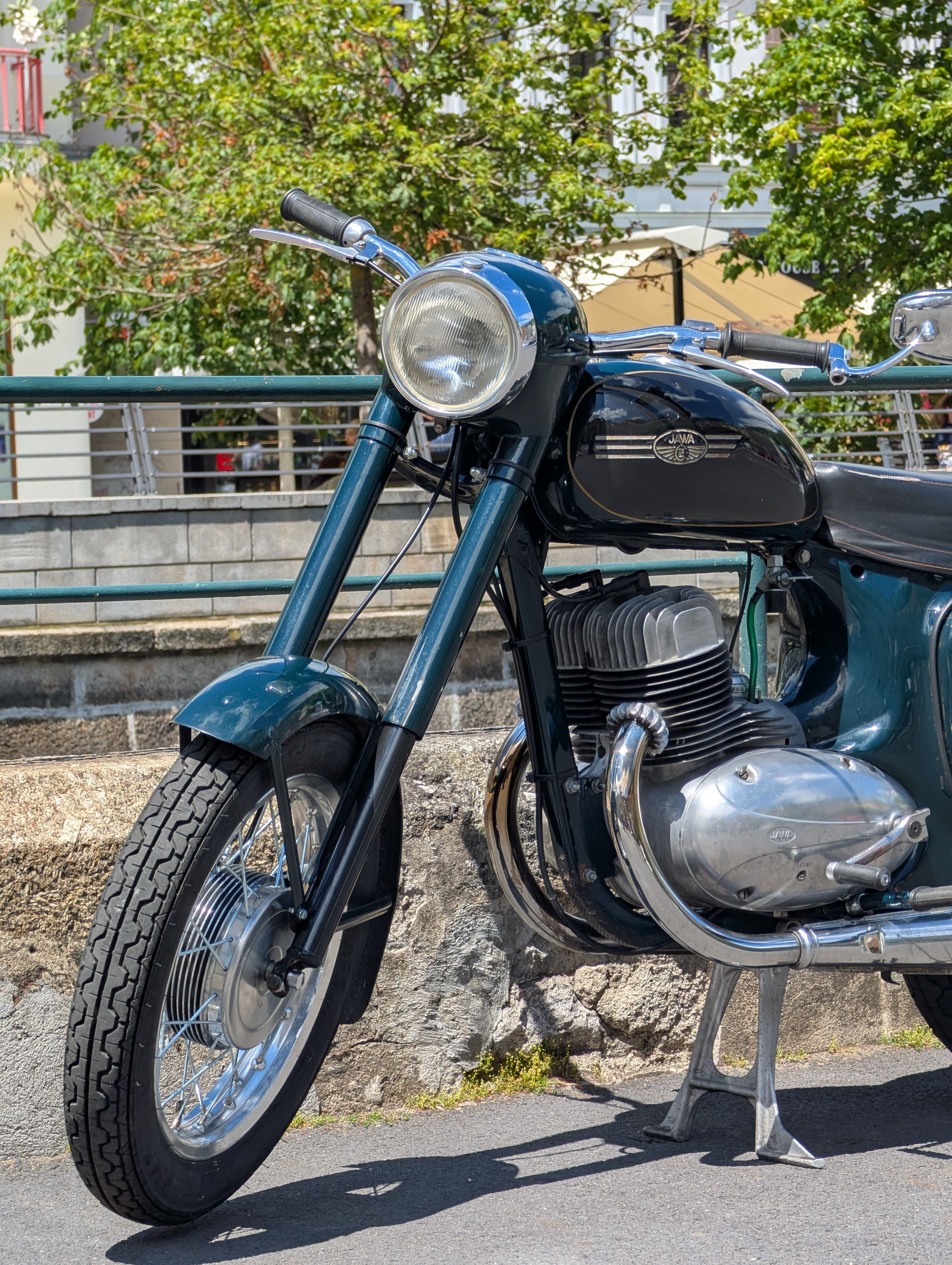 A classic motorcycle parked outdoors in Karlovy Vary, Czechia on a sunny day.