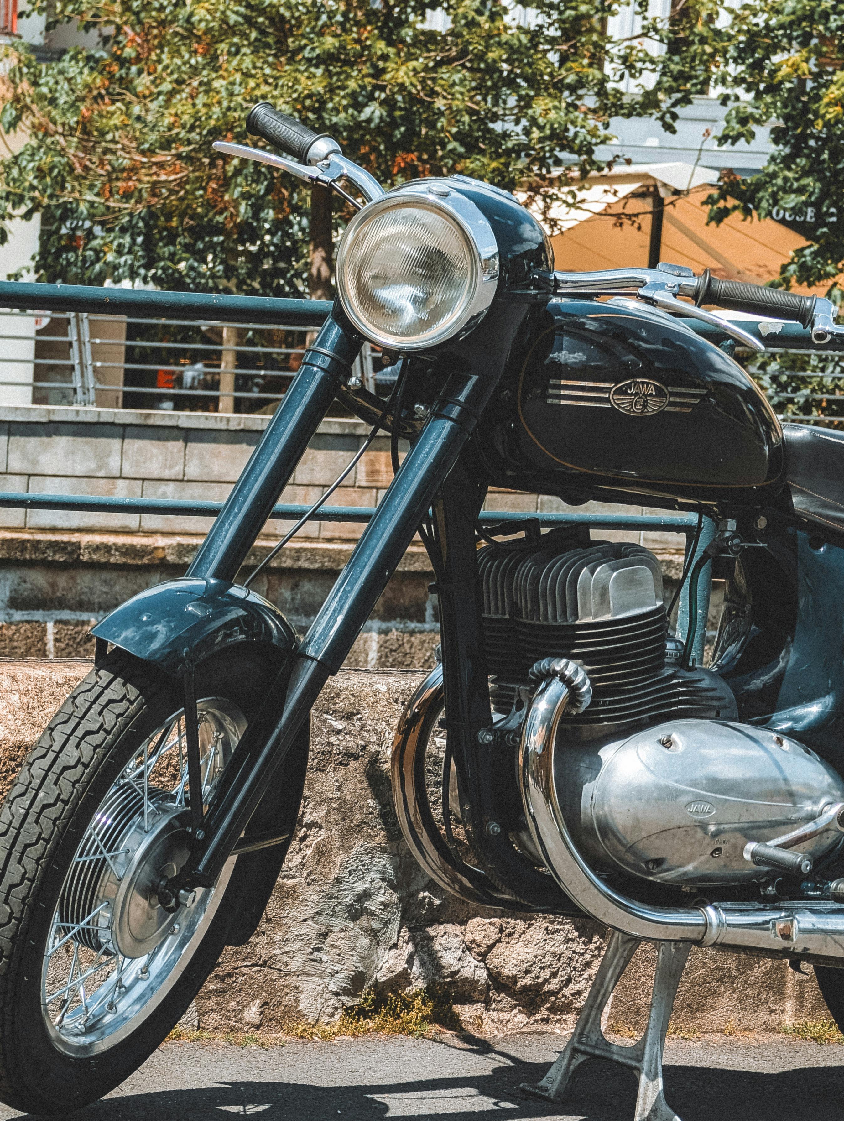 Close-up of a vintage motorcycle parked outdoors in Karlovy Vary, Czechia.